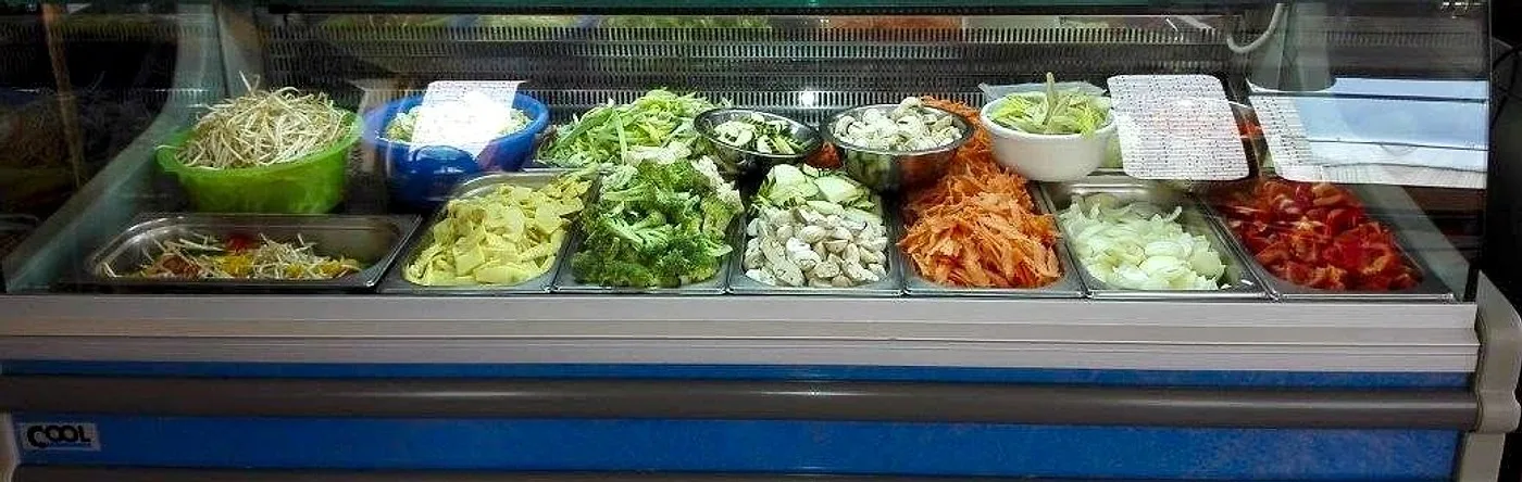 Die Auslage mit frisch geschnittenem Gemüse: Sojasprossen, Brokkoli, Champignons, Möhren, Zwiebeln