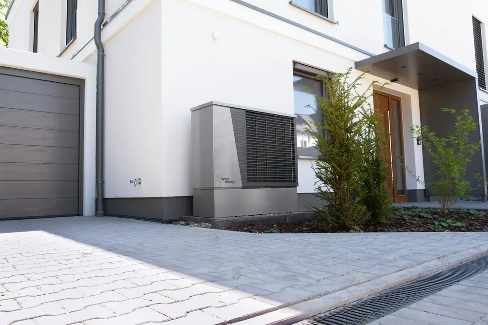 Wärmepumpe an der Fassade eines modernen Wohnhauses