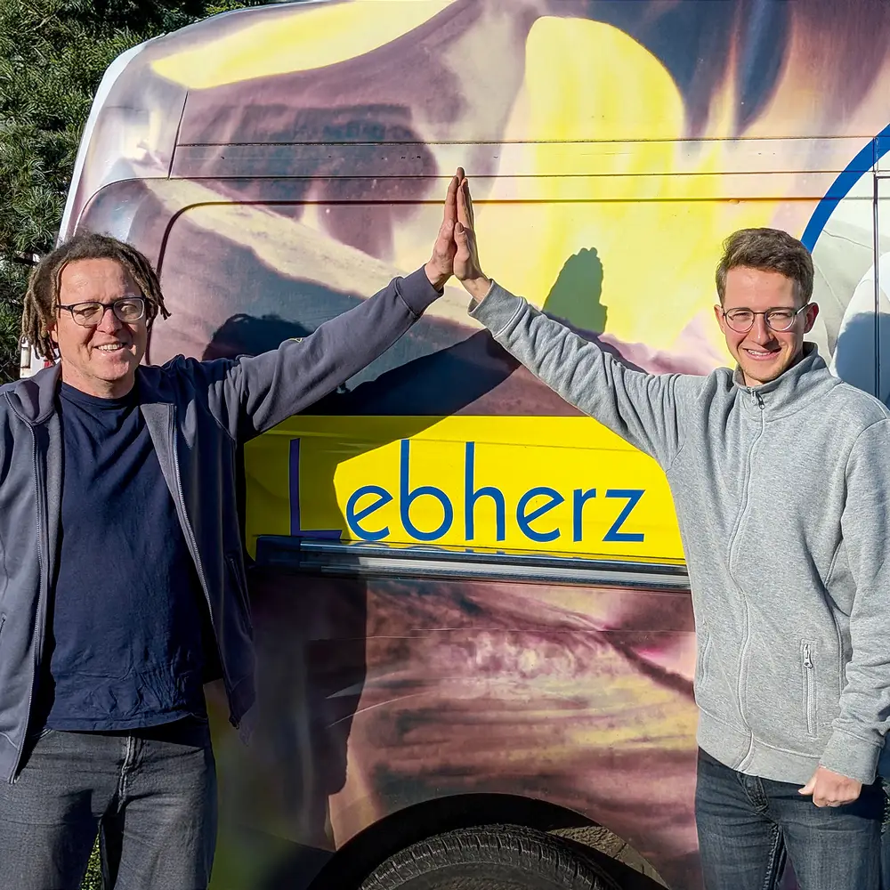 Zwei Mitarbeiter am Firmenwagen