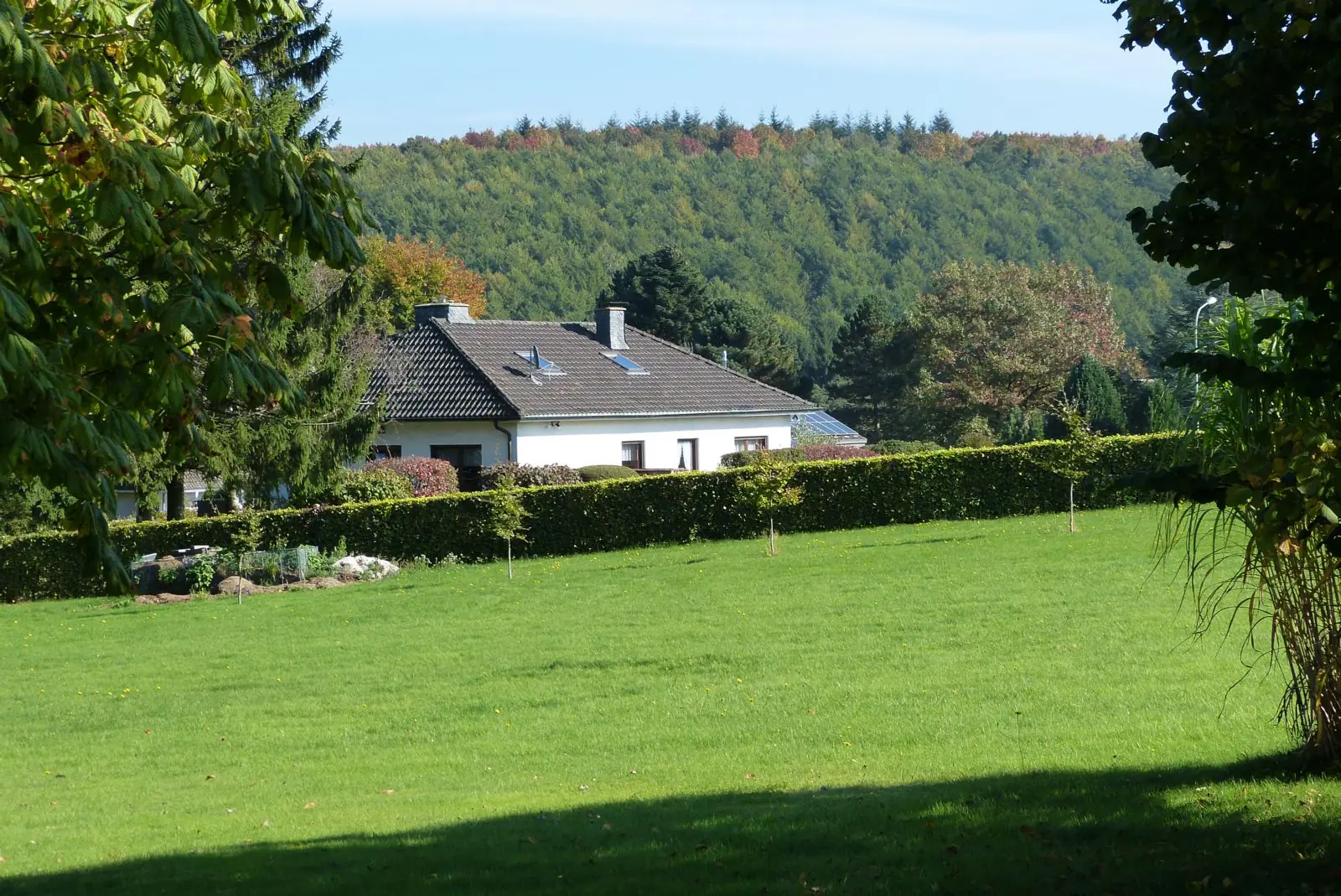 Großer Garten mit Blick auf bewaldete Hügel der Eifel