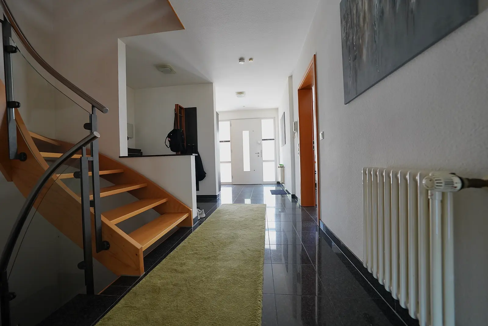 Helle Diele mit Treppe und Blick auf die Haustür