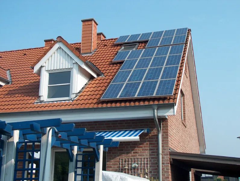 Photovoltaik auf einem roten Ziegeldach mit Gaube